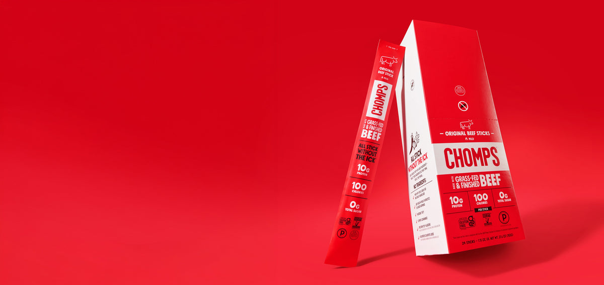 Red and white packaging for Chomps Grass-Fed & Finished Beef Sticks, showing a tall box and a single stick package on a solid red background.
